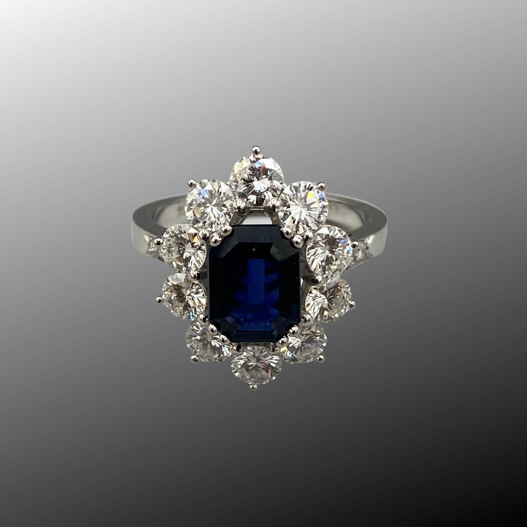 Bague or gris 750 d'un saphir taille émeraude entouré de diamants taille brillant