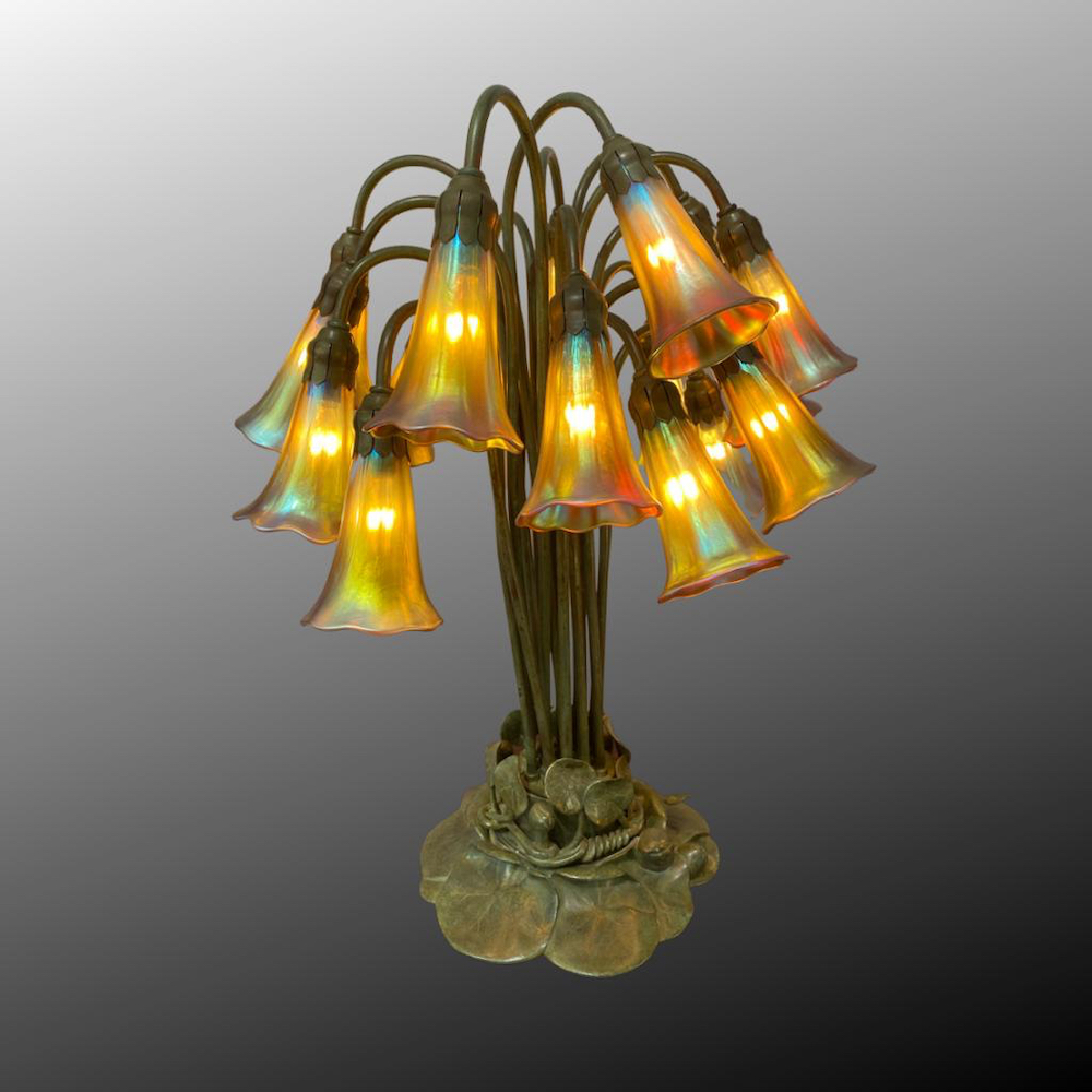   TIFFANY STUDIOS N.Y. TISCHLAMPE 18-LIGHT LILY, ca. 1910, Bronze braun patiniert und irisiertes Glas. Fuss und Schirme tragen Tiffany Signaturen. H. 56 cm.   signed and numbered 583 56 cm