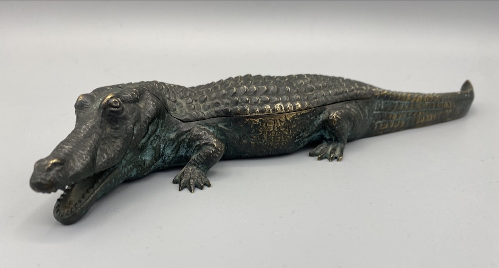 Krokodil mit aufklappbarem Rücken. Innen mit liegendem Frauenakt. Bronze grün und goldfarben patiniert. Am Schwanz gemarkt AUSTRIA. Wohl Franz Bergmann Giesserei.